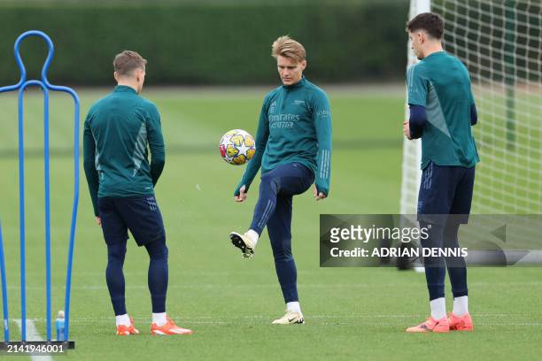Arsenal's Norwegian midfielder Martin Odegaard controls the ball during a training session on the eve of their UEFA Champions League quarter final...