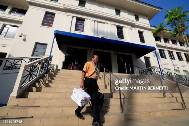 Man carries documents outside the courthouse where the "Panama Papers" trial is being held in Panama City on April 8, 2024. 27 people will be tried...