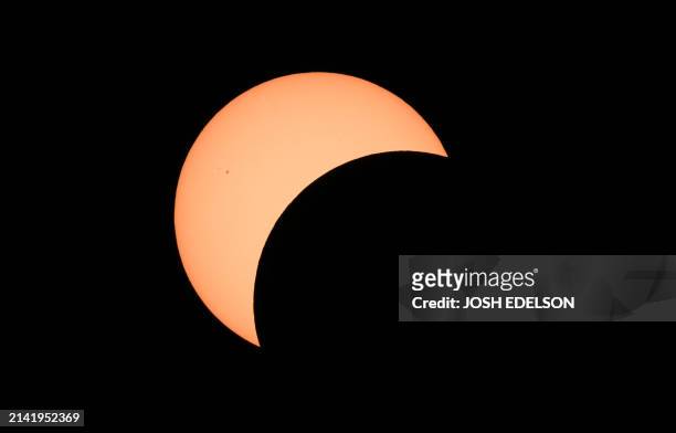 Early stages of a total solar eclipse shows the moon crossing in front of the sun in Bloomington, Indiana, on April 8, 2024. This year's path of...