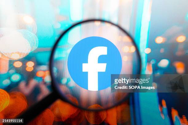 In this photo illustration, a Facebook logo seen displayed on a computer screen through a magnifying glass.