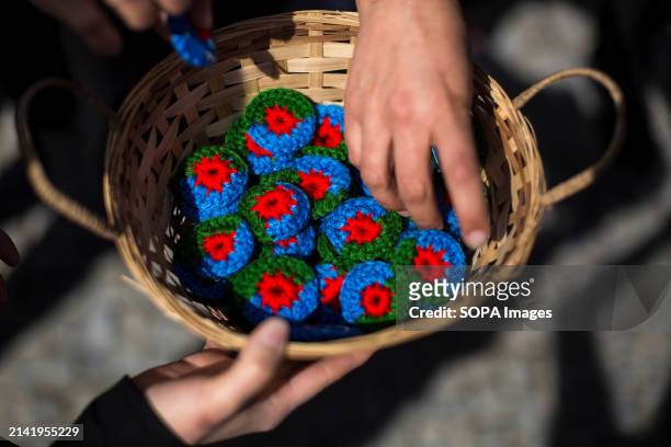 Woman picks up woven flags of the Gypsy people, during the institutional event to celebrate the International Day of the Gypsy People, on the Segovia...