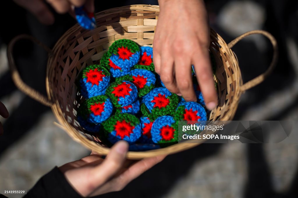 A woman picks up woven flags of the Gypsy people, during the...