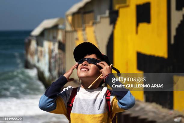 Kid wears special sunglasses to observe the partial solar eclipse in Playas de Tijuana, Baja California state, Mexico on April 8, 2024. This year's...