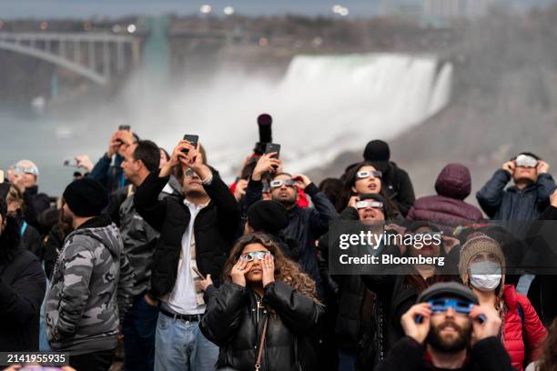 Visitors wear solar viewing glasses during an eclipse viewing event in Niagara Falls, Ontario, Canada, on Monday, April 8, 2024. A total solar...