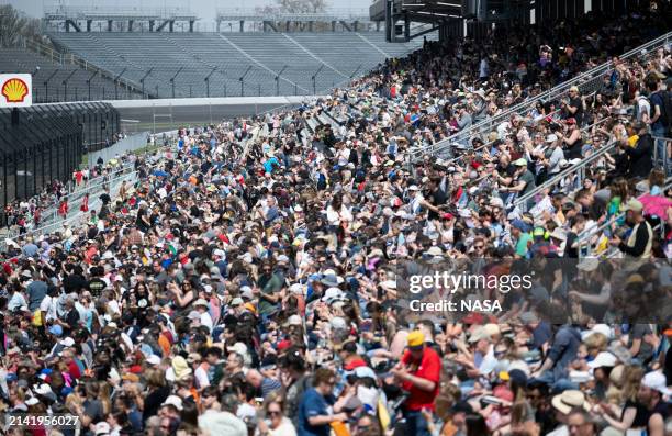 In this handout provided by the National Aeronautics and Space Administration , attendees watch from the grandstands of the Indianapolis Motor...