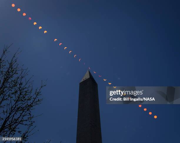 In this NASA handout, the Moon is seen passing in front of the Sun, with the top of the Washington Monument in silhouette, during a partial solar...