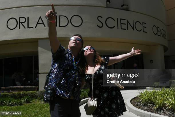 People observe the total solar eclipse through safety glasses at an eclipse watch party at the Orlando Science Center on April 8, 2024 in Orlando,...