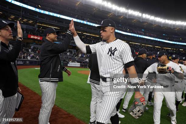 Manager Aaron Boone of the New York Yankees high fives Aaron Judge after the game against the Miami Marlins at Yankee Stadium on April 8 in New York,...