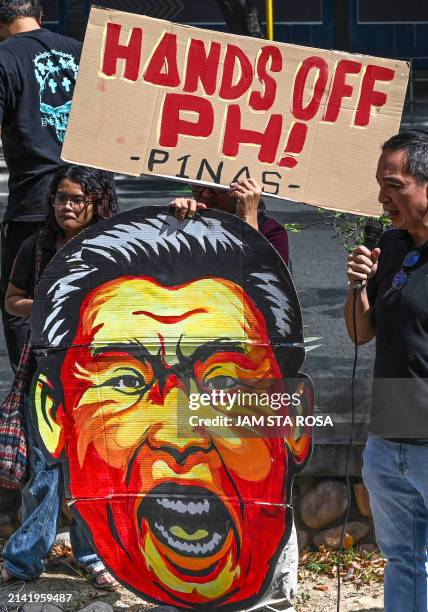 Caricature of China's President Xi Jinping is held by an activist during a demonstration to condemn China's recent actions in disputed waters of the...