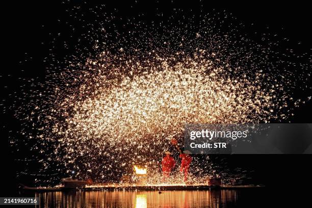This photo taken on April 8, 2024 shows sparks created by molten iron being splashed during the Zhuang Song Festival, also known as "San Yue San"...