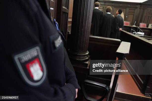 April 2024, Hamburg: Lawyers stand in front of the accused women in the courtroom at the Criminal Justice Building at the start of the trial against...