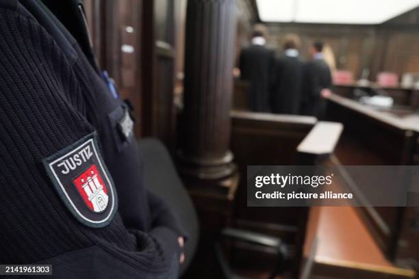 April 2024, Hamburg: Lawyers stand in front of the accused women in the courtroom at the Criminal Justice Building at the start of the trial against...