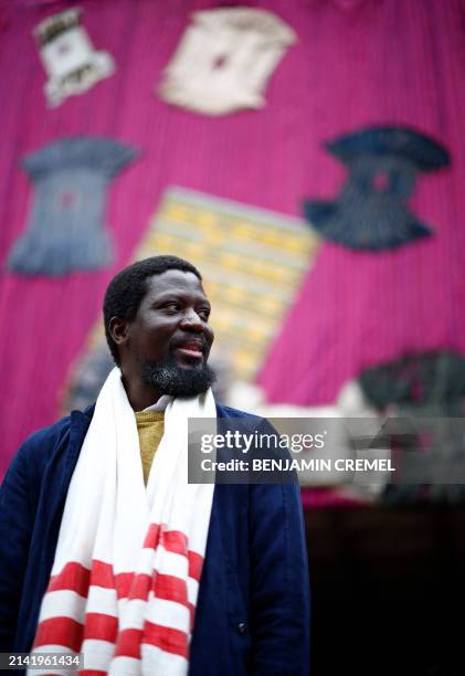 Ghanaian artist Ibrahim Mahama poses for a photograph in front of his installation entitled 'Purple Hibiscus' at the Barbican centre in central...