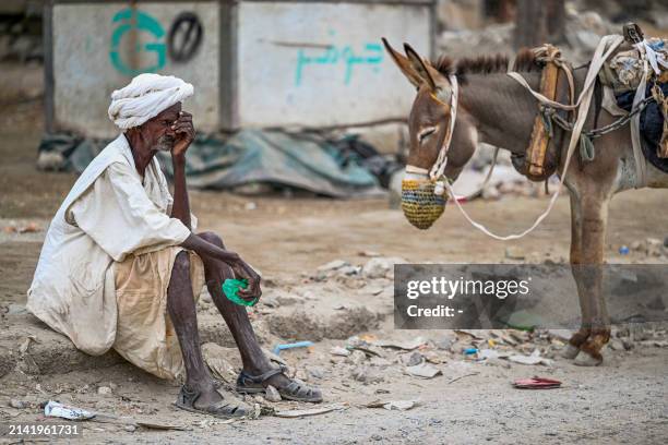 An elderly man waits to refill his donkey-drawn water tank during a water crisis in Port Sudan in the Red Sea State of war-torn Sudan on April 9,...