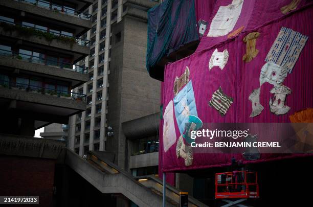 Workers put the finishing touches to an artwork entitled 'Purple Hibiscus' by Ghanaian artist Ibrahim Mahama at the Barbican centre in central London...