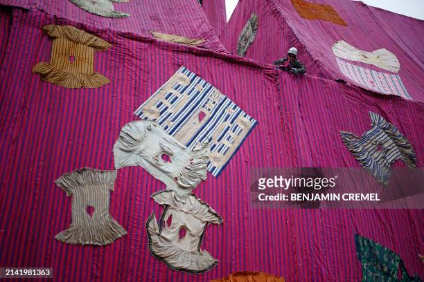 Workers put the finishing touches to an artwork entitled 'Purple Hibiscus' by Ghanaian artist Ibrahim Mahama at the Barbican centre in central London...