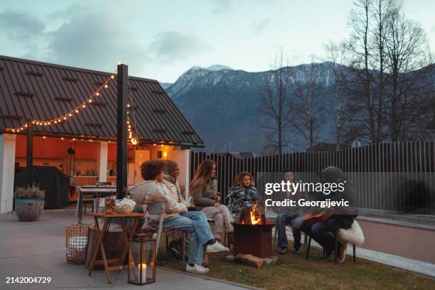 family time by the firepit - cosy fire stock pictures, royalty-free photos & images