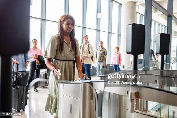 hispanic non binary person self-scanning the boarding pass - embarcar imagens e fotografias de stock