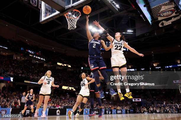 Arnold of the UConn Huskies shoots the ball over Caitlin Clark of the Iowa Hawkeyes in the first half during the NCAA Women's Basketball Tournament...