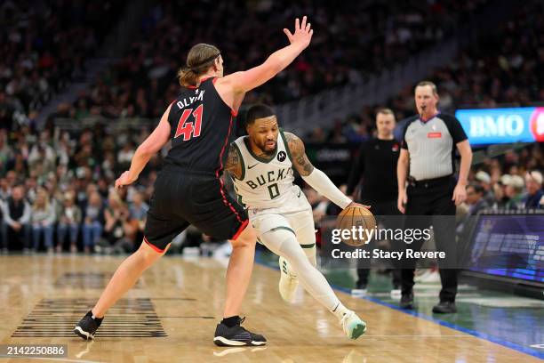 Damian Lillard of the Milwaukee Bucks drives around Kelly Olynyk of the Toronto Raptors during the second half of a game at Fiserv Forum on April 05,...