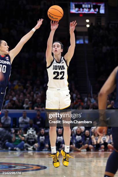 Caitlin Clark of the Iowa Hawkeyes shoots a three point basket over Nika Muhl of the UConn Huskies in the second half during the NCAA Women's...