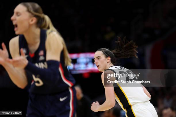 Caitlin Clark of the Iowa Hawkeyes looks on as Paige Bueckers of the UConn Huskies reacts in the second half during the NCAA Women's Basketball...