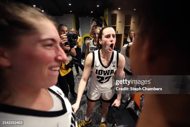 Caitlin Clark of the Iowa Hawkeyes celebrates with the team after beating the UConn Huskies in the NCAA Women's Basketball Tournament Final Four...