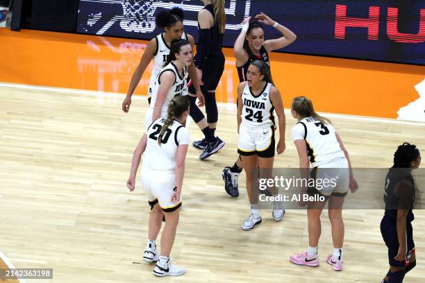The Iowa Hawkeyes and the UConn Huskies react after a foul in the second half during the NCAA Women's Basketball Tournament Final Four semifinal game...