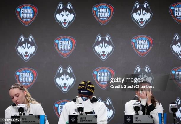 Paige Bueckers, Aaliyah Edwards and Nika Muhl of the UConn Huskies, from left, react as they speak with the media after losing to the Iowa Hawkeyes...