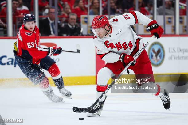 Brett Pesce of the Carolina Hurricanes skates with the puck in front of Ivan Miroshnichenko of the Washington Capitals during the first period of the...