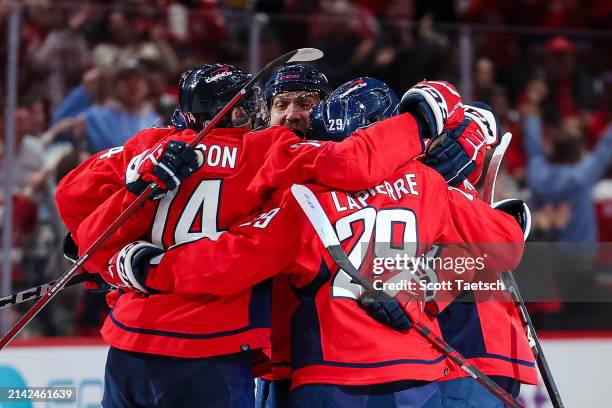 John Carlson of the Washington Capitals celebrates with teammates after scoring a goal against the Carolina Hurricanes during the third period of the...