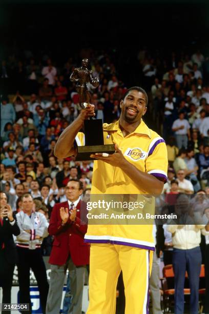 Earvin "Magic" Johnson of the Los Angeles Lakers holds up the NBA Most Valuable Player Award in 1986 in Inglewood, California. NOTE TO USER: User...