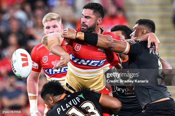 Jesse Bromwich of the Dolphins passes as he is tackled during the round five NRL match between Dolphins and Wests Tigers at Suncorp Stadium, on April...