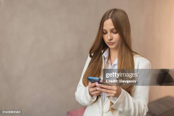 blonde woman in white business suit working at a laptop. style. long hair - draft first round stock pictures, royalty-free photos & images
