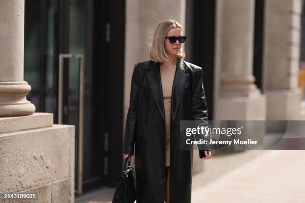 Isabelle Hartmann seen wearing Celine black sunglasses, vintage beige short dress, Magda Butrym black leather long coat and Hermès Kelly black...