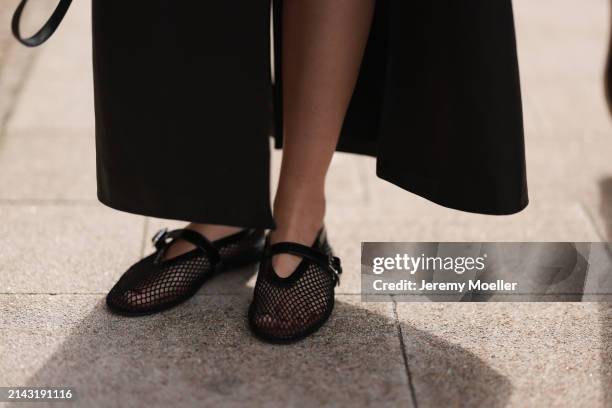 Isabelle Hartmann seen wearing Magda Butrym black leather long coat and Alaia black shiny leather mesh ballerinas / flats on April 05, 2024 in...