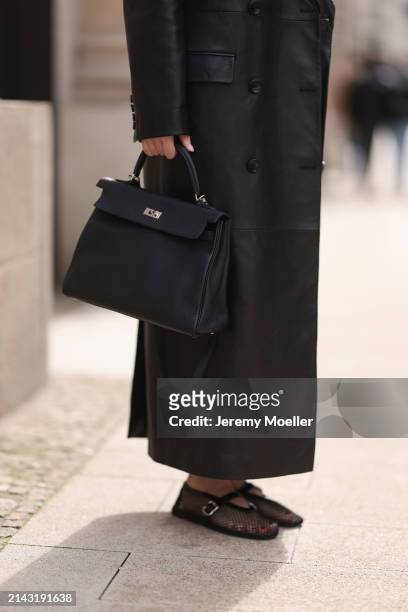 Isabelle Hartmann seen wearing Magda Butrym black leather long coat, Hermès Kelly black leather bag and Alaia black shiny leather mesh ballerinas /...