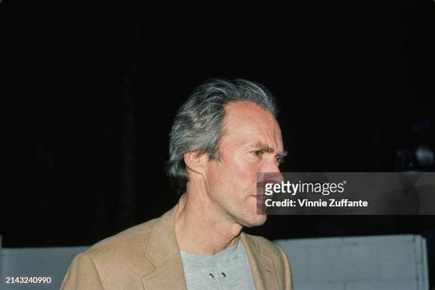 American actor and film director Clint Eastwood wearing a tan jacket over a grey crew neck shirt, United States, April 1985.