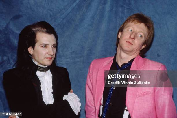 British singer and musician David Vanian, wearing a black jacket with a white ruffle shirt with frilled cuffs, and British drummer Rat Scabies, who...