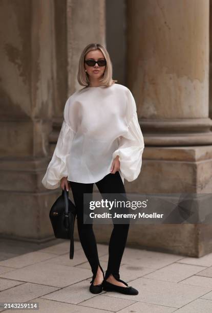 Isabelle Hartmann seen wearing Vehla Eyewear black / brown sunglasses, Nootka gold earrings, Khaite oversized puffy ruffled long sleeve silk top,...