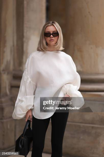 Isabelle Hartmann seen wearing Vehla Eyewear black / brown sunglasses, Khaite oversized puffy ruffled long sleeve silk top, Isabelle Hartmann x...