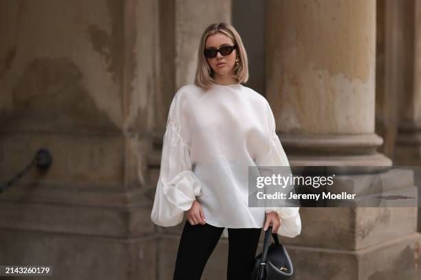 Isabelle Hartmann seen wearing Vehla Eyewear black / brown sunglasses, Nootka gold earrings, Khaite oversized puffy ruffled long sleeve silk top,...