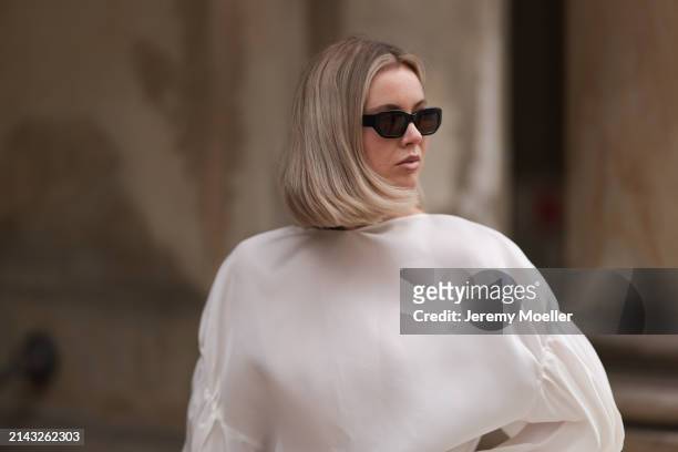 Isabelle Hartmann seen wearing Vehla Eyewear black / brown sunglasses, Khaite oversized puffy ruffled long sleeve silk top on April 05, 2024 in...