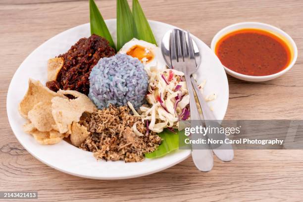 nasi kerabu blue colored rice with fish sambal - clitoria fotografías e imágenes de stock