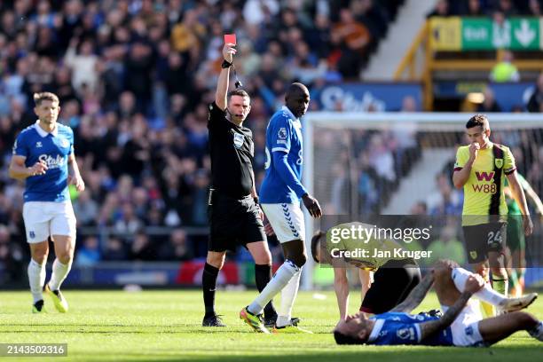 Referee Michael Oliver gives a red card to Dara O'Shea of Burnley during the Premier League match between Everton FC and Burnley FC at Goodison Park...