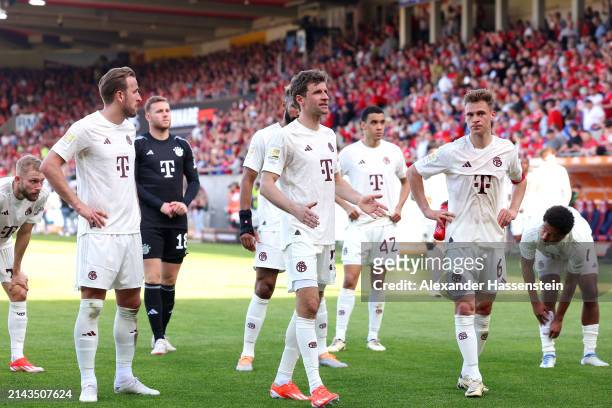 Harry Kane, Thomas Mueller and Joshua Kimmich of Bayern Munich look dejected following defeat in the Bundesliga match between 1. FC Heidenheim 1846...