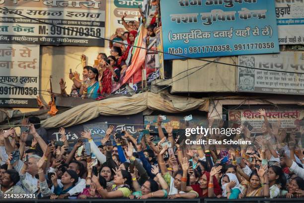 Supporters wave at the arrival of Prime Minister Narendra Modi who greets the public at a roadshow on April 06, 2024 in Ghaziabad, Uttar Pradesh,...