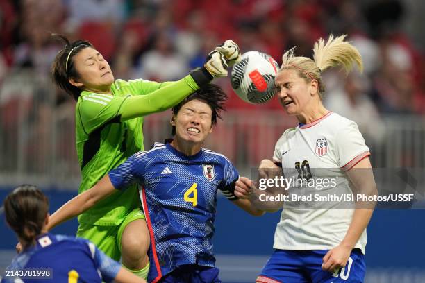Lindsey Horan of the United States goes up for a header with Saki Kumagai of Japan as Ayaka Yamashita of Japan looks to punch the ball clear during...