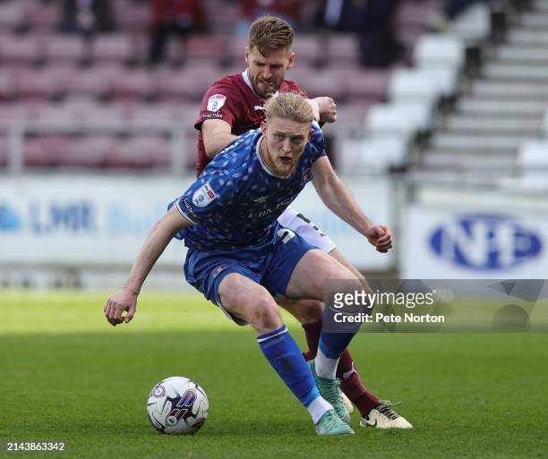 Luke Armstrong of Carlisle United looks to control the ball under pressure from Jon Guthrie of Northampton Town during the Sky Bet League One match...
