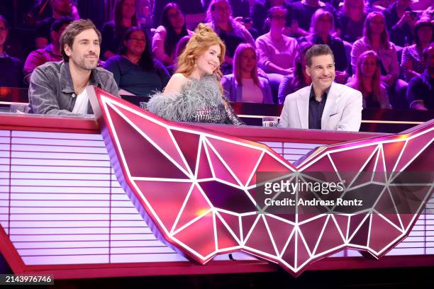 Max Giesinger, Palina Rojinski and Rick Kavanian are seen on stage during the first showing of Season 10 of "The Masked Singer" at MMC Studios on...